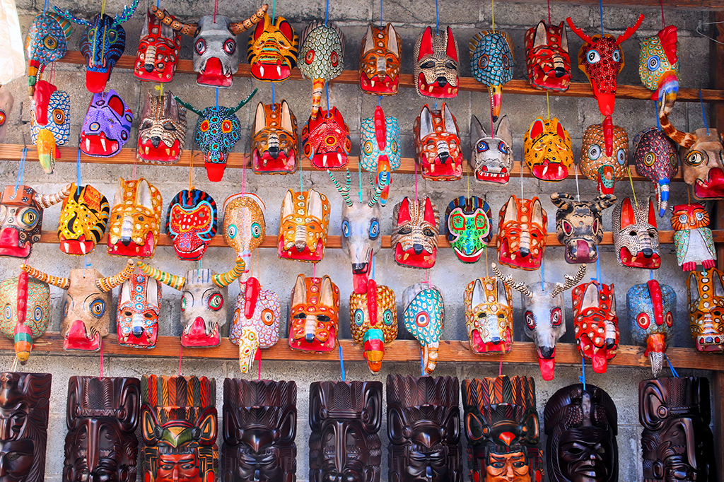 "Colorful wooden masks at Chichicastenango Market, a cultural treasure to explore on Guatemala Vacation Packages."